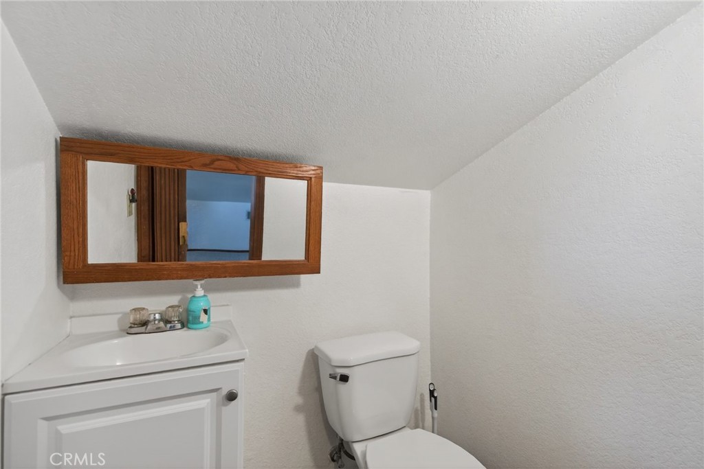 14435 Wood Road Riverside, CA 92508 - Photo 25 of 66 a bathroom with a toilet a sink and mirror