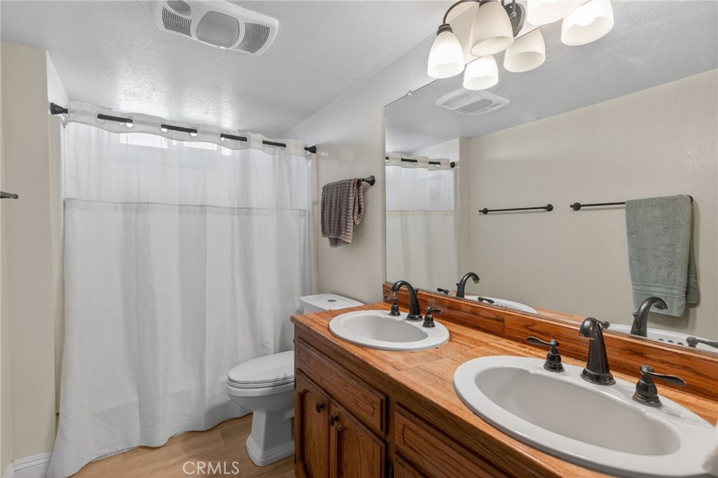 14435 Wood Road Riverside, CA 92508 - Photo 30 of 66 a bathroom with a sink toilet double vanity and shower