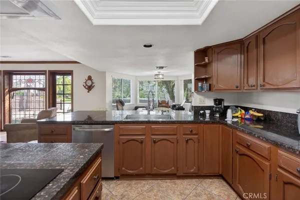 a kitchen with granite countertop a sink stove and cabinets