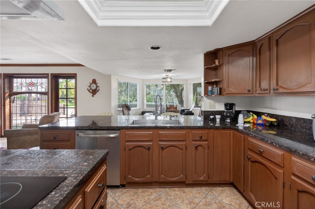 14435 Wood Road Riverside, CA 92508 - Photo 9 of 66 a kitchen with granite countertop a sink stove and cabinets