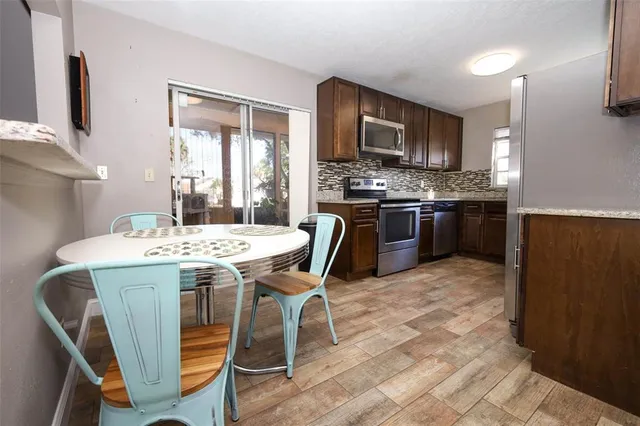 a kitchen with granite countertop a sink stove and microwave