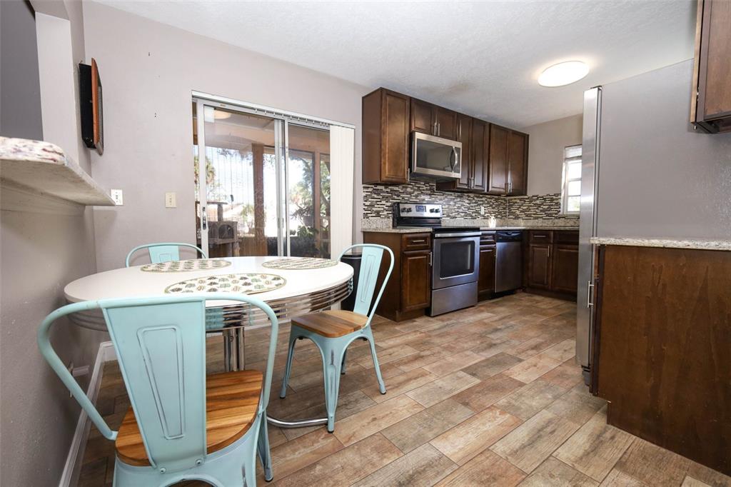1531 Lawndale Circle Winter Park, FL 32792 - Photo 11 of 44 a kitchen with stainless steel appliances kitchen island granite countertop a sink a stove a refrigerator a stove top oven a dining table and chairs