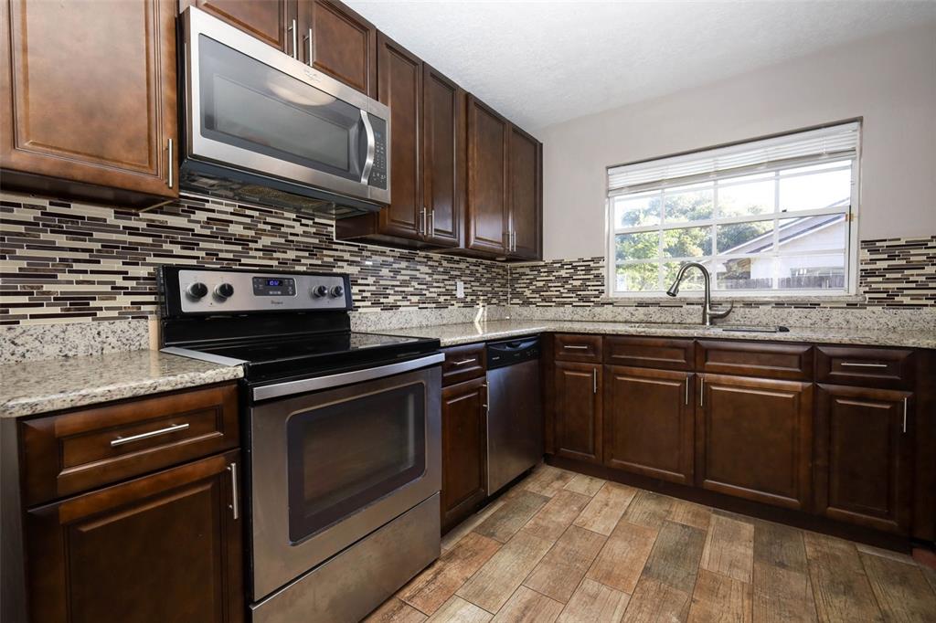 1531 Lawndale Circle Winter Park, FL 32792 - Photo 12 of 44 a kitchen with granite countertop a sink stove and microwave
