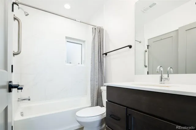 a bathroom with a sink a toilet a mirror and shower