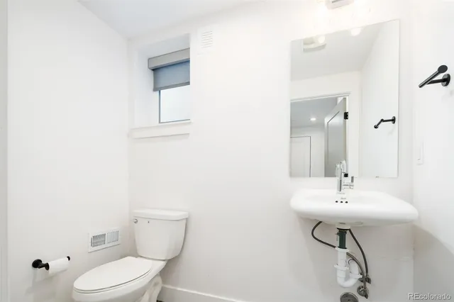 a bathroom with a sink a toilet and mirror