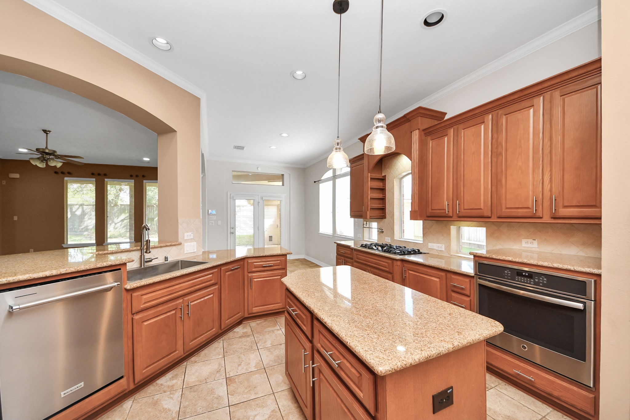 17618 Raven Canyon Lane Houston, TX 77095 - Photo 7 of 45 A bright and open kitchen featuring a large island, ample cabinet storage, and built-in microwave, seamlessly connected to the living space.