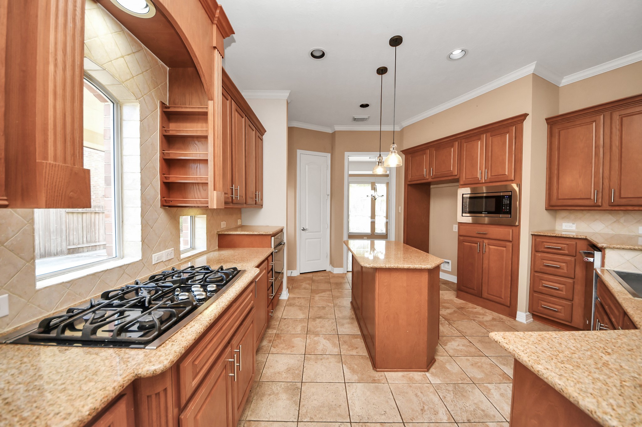 17618 Raven Canyon Lane Houston, TX 77095 - Photo 8 of 45 Gorgeous kitchen with gas stove, stylish cabinetry, and beautiful arch detail above the windows. Ideal for culinary enthusiasts.