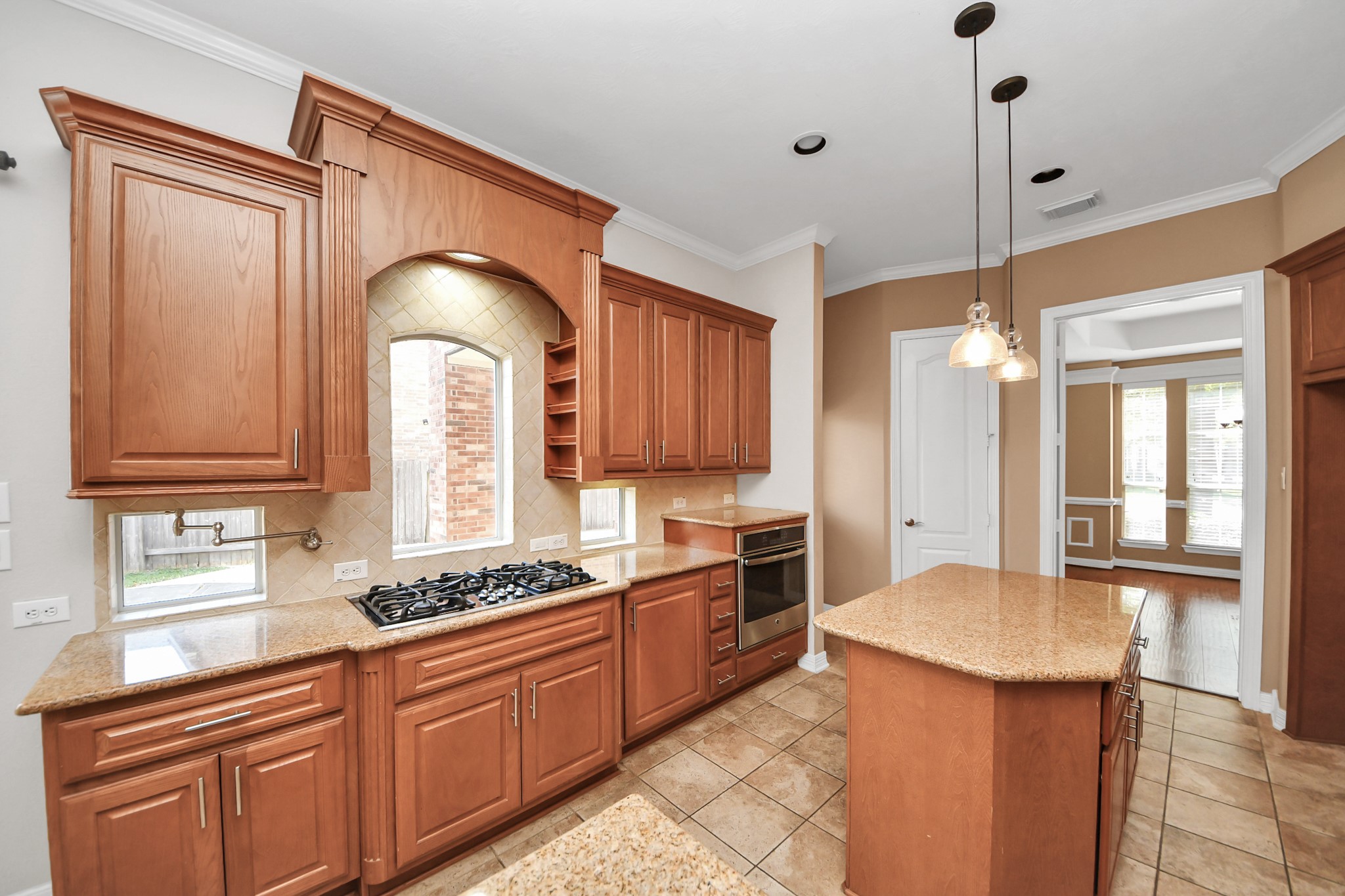 17618 Raven Canyon Lane Houston, TX 77095 - Photo 9 of 45 Fully equipped kitchen with modern finishes, including pendant lighting, granite countertops, and ample space for cooking and meal prep.