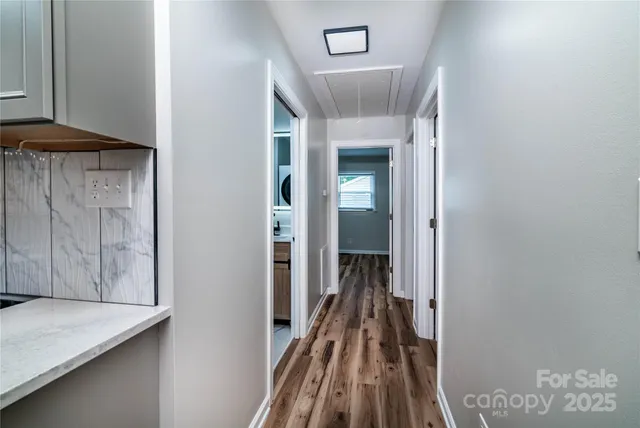 a view of a hallway with wooden floor and staircase