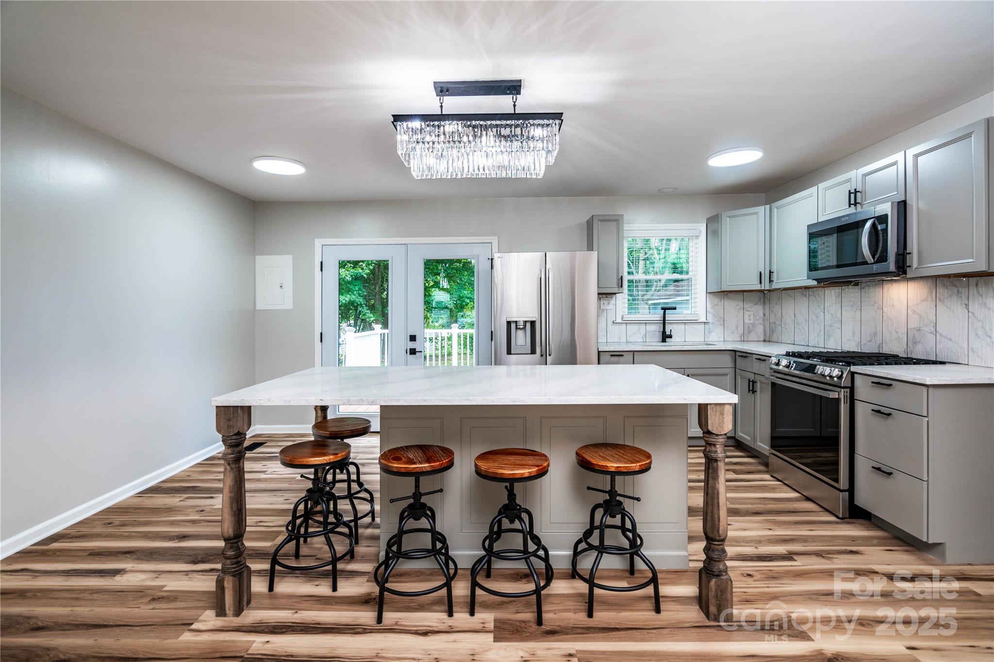 305 Linden Circle Gastonia, NC 28054 - Photo 10 of 37 a kitchen with stainless steel appliances a table chairs in it and wooden floors