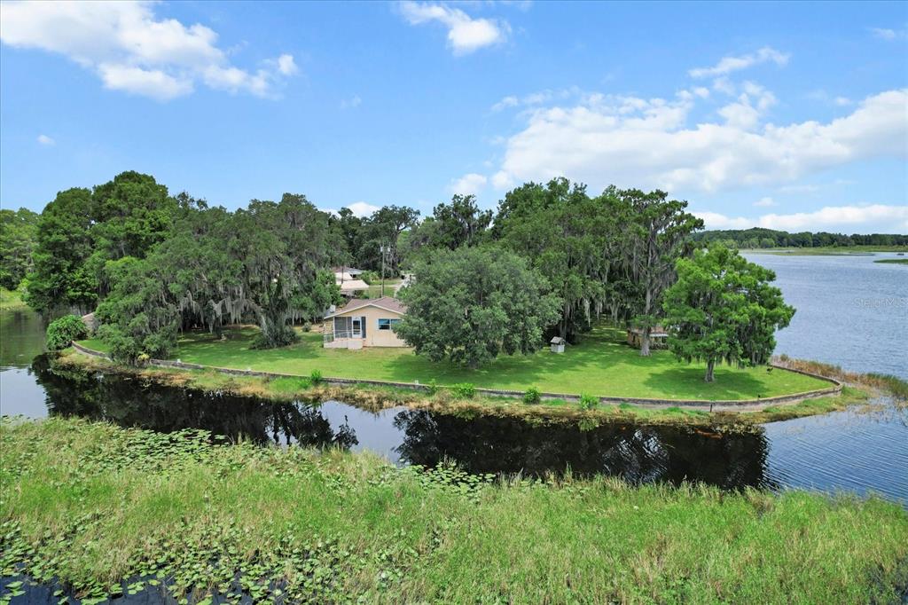 1226 South Telephone Point Road Inverness, FL 34450 - Photo 19 of 43 a view of a lush green outdoor space with a lake view