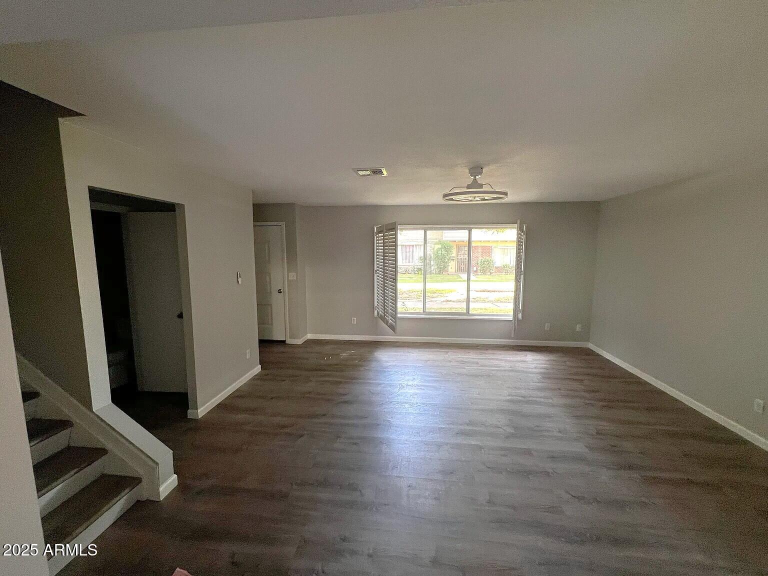 4505 North 17th Avenue Phoenix, AZ 85015 - Photo 2 of 12 an empty room with wooden floor and windows