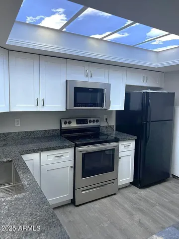 a kitchen with stainless steel appliances granite countertop a stove a refrigerator and a microwave