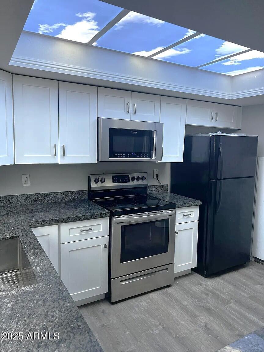 4505 North 17th Avenue Phoenix, AZ 85015 - Photo 4 of 12 a kitchen with stainless steel appliances granite countertop a stove a refrigerator and a microwave