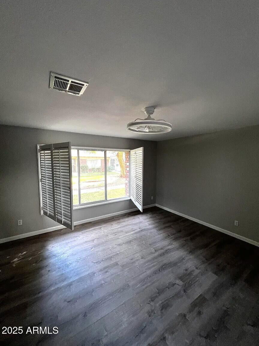 4505 North 17th Avenue Phoenix, AZ 85015 - Photo 8 of 12 an empty room with wooden floor and windows