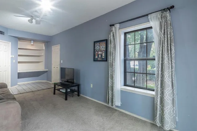 a view of a livingroom with workspace and a window