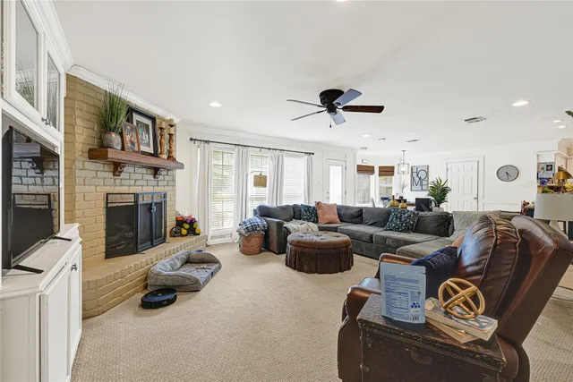 a living room with furniture ceiling fan and a fireplace