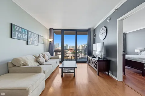 a living room with furniture large window and wooden floor