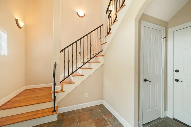a bathroom with a granite countertop sink a mirror a toilet and shower