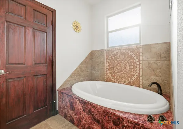 a bathroom with a tub and a window