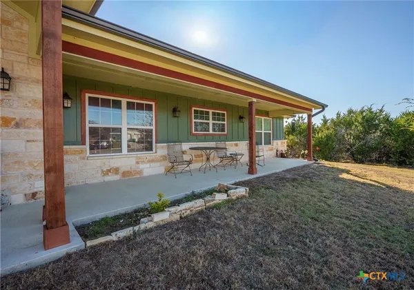 a backyard of a house with yard and outdoor seating