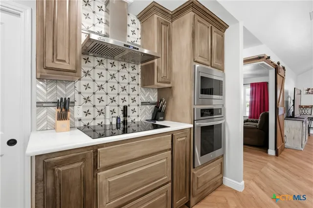 a kitchen with stainless steel appliances kitchen island granite countertop a refrigerator and a stove