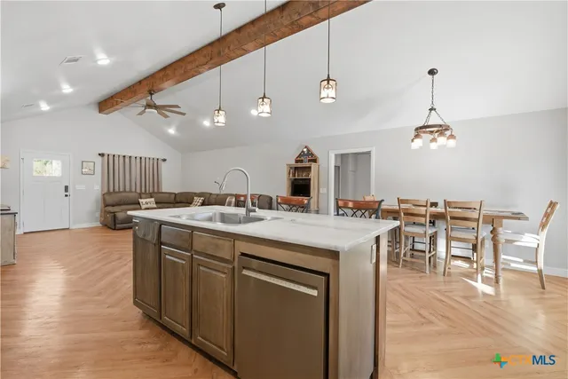 a large kitchen with kitchen island a sink table and chairs