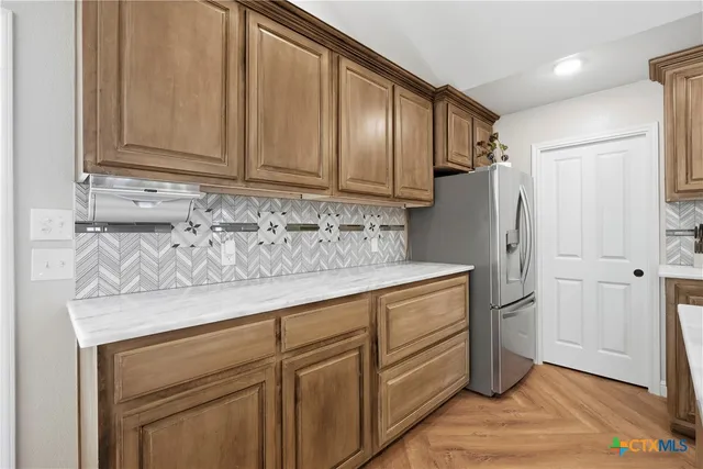 a kitchen with stainless steel appliances granite countertop cabinets and wooden floor