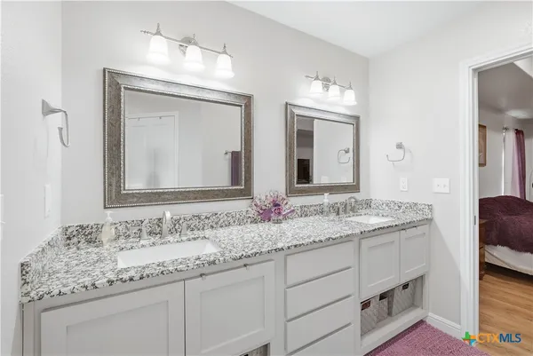 a bathroom with a granite countertop sink double and mirror