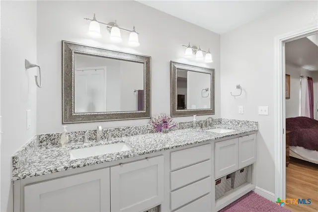 a bathroom with a granite countertop sink double and mirror