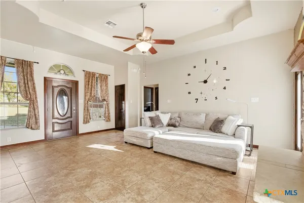 a living room with furniture and a ceiling fan