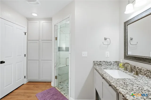 a bathroom with a granite countertop sink and a mirror