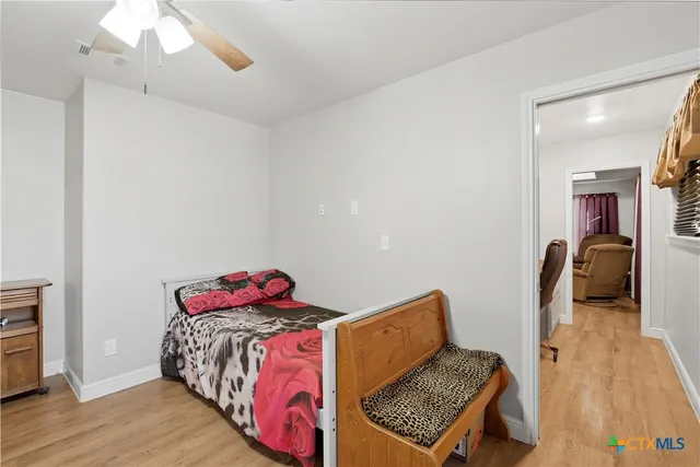 a bedroom with a bed and wooden floor