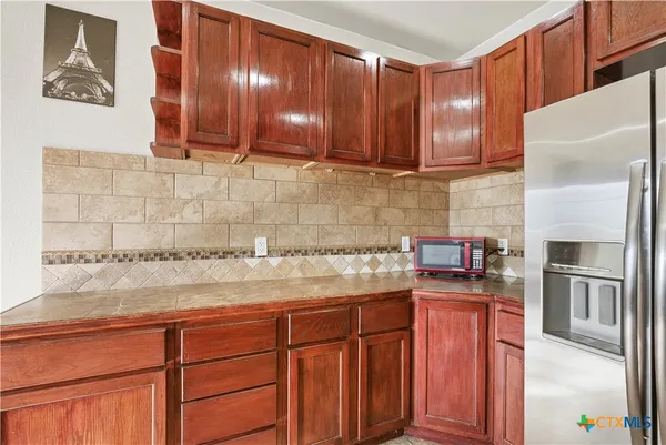 a kitchen with stainless steel appliances granite countertop a refrigerator and a stove top oven