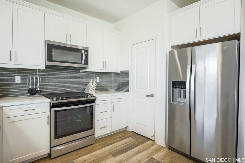 8615 Chaparral Way Santee, CA 92071 - Photo 15 of 46 a kitchen with white cabinets and stainless steel appliances
