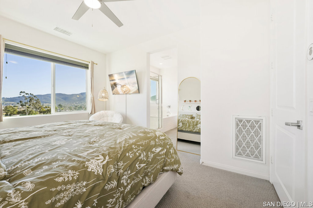 8615 Chaparral Way Santee, CA 92071 - Photo 22 of 46 a bedroom with a bed mirror and a large window