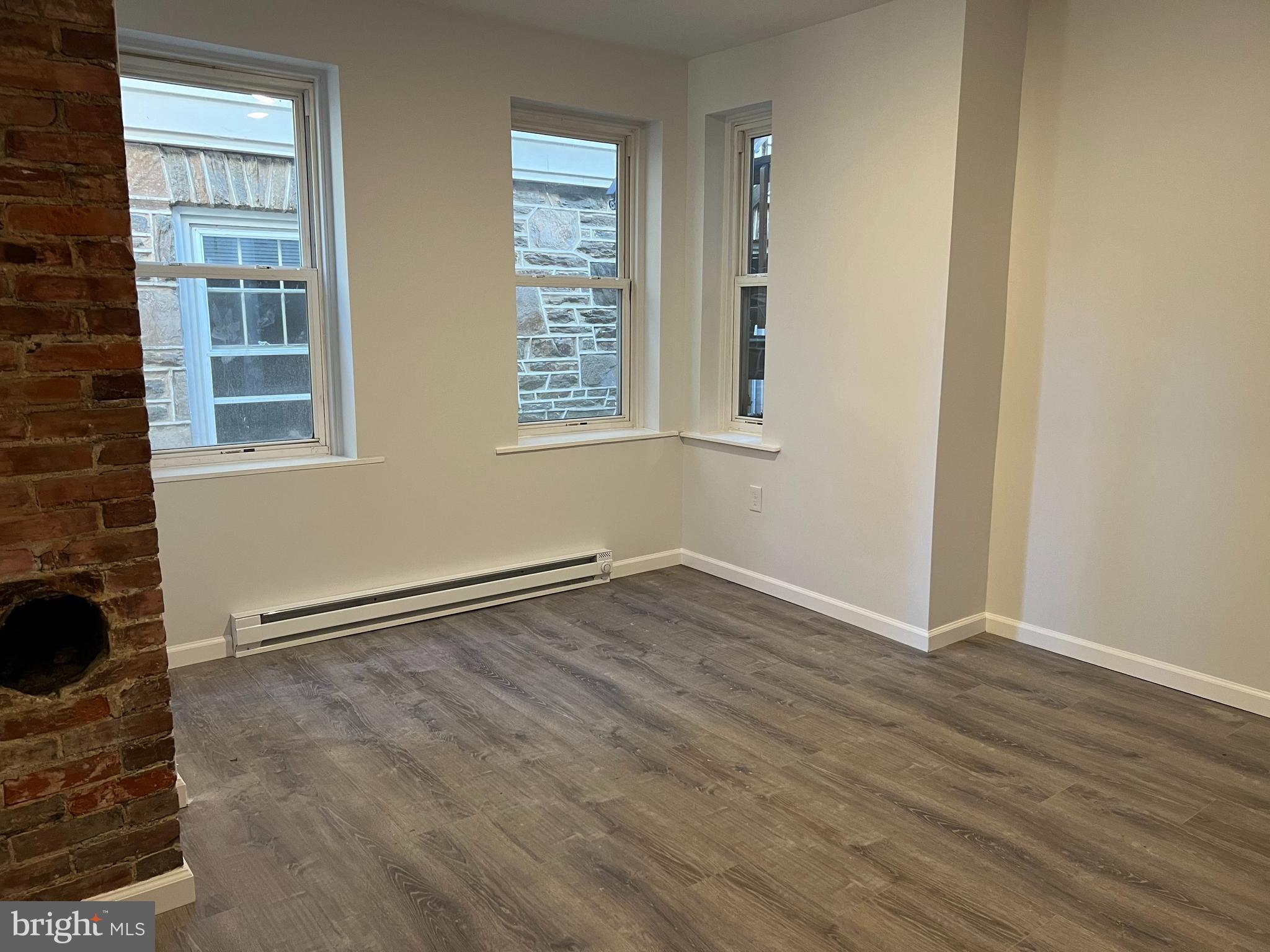 232 Center Street, Unit 1 Kennett Square, PA 19348 - Photo 2 of 7 an empty room with wooden floor and windows