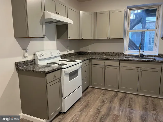 a kitchen with granite countertop cabinets stainless steel appliances and a sink