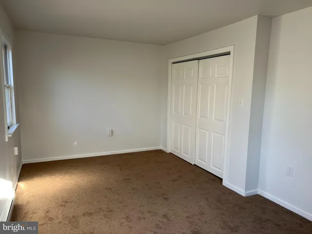 an empty room with a wooden floor and windows