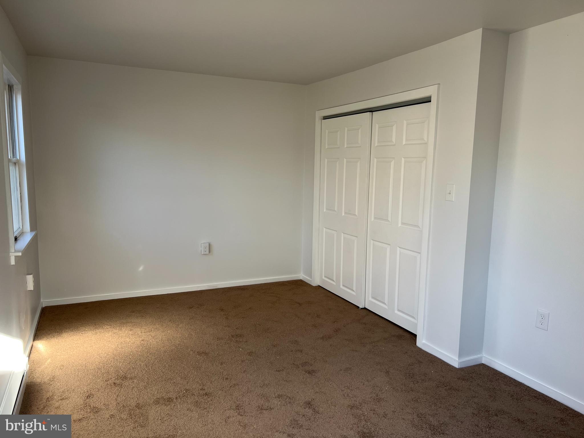 232 Center Street, Unit 1 Kennett Square, PA 19348 - Photo 5 of 7 an empty room with a wooden floor and windows