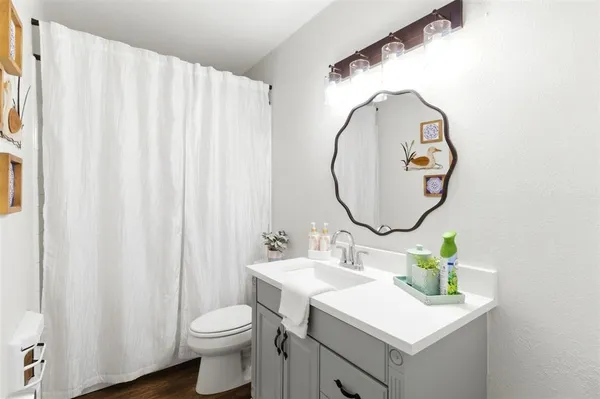 a bathroom with a sink mirror and toilet