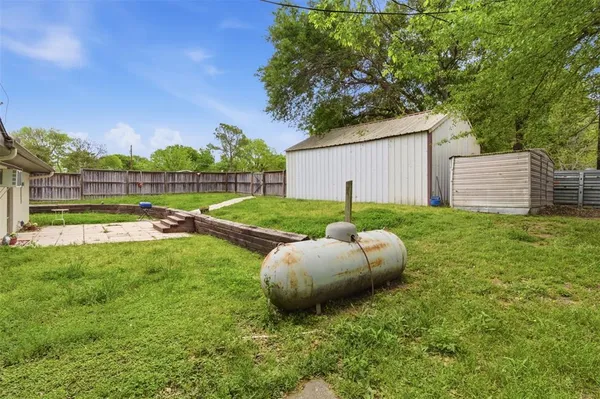 a view of a backyard with table and chairs and wooden fence
