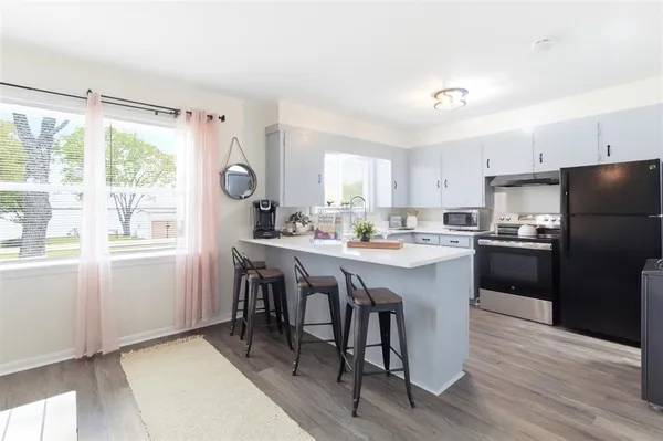 a kitchen with a table chairs refrigerator and window