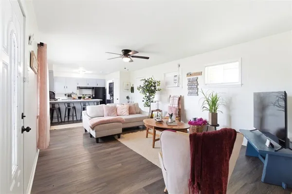 a living room with furniture kitchen view and a flat screen tv