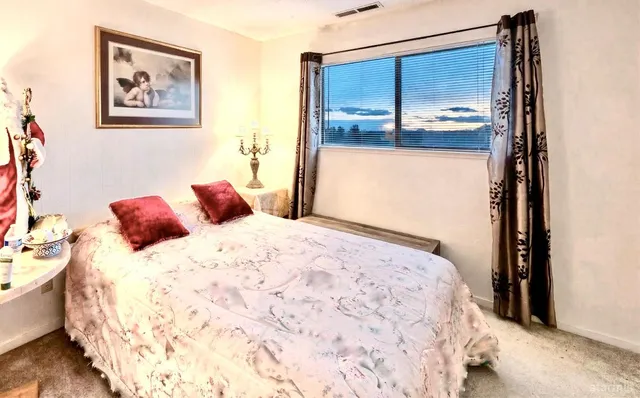 a bedroom with a bed and painting on the wall