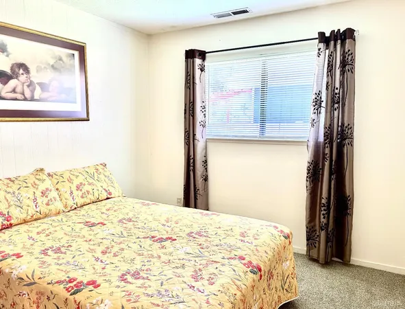 a bedroom with a large window and a wooden floor