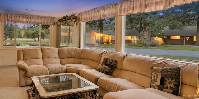 a living room with furniture and a floor to ceiling window
