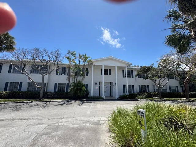 a view of a white house with a yard in front of it