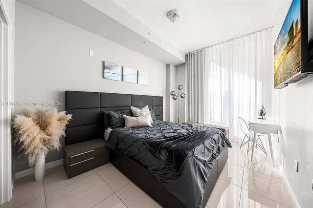 a bedroom with a bed and a flat screen tv