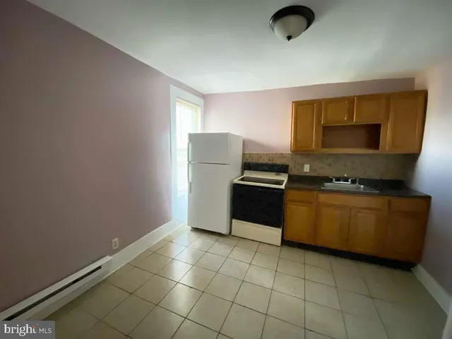 a kitchen with granite countertop a stove a sink and a window